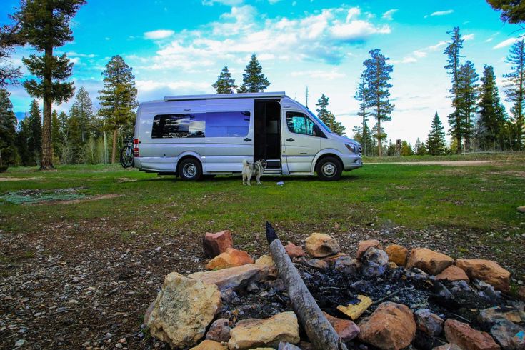 a camper van parked next to a fire pit