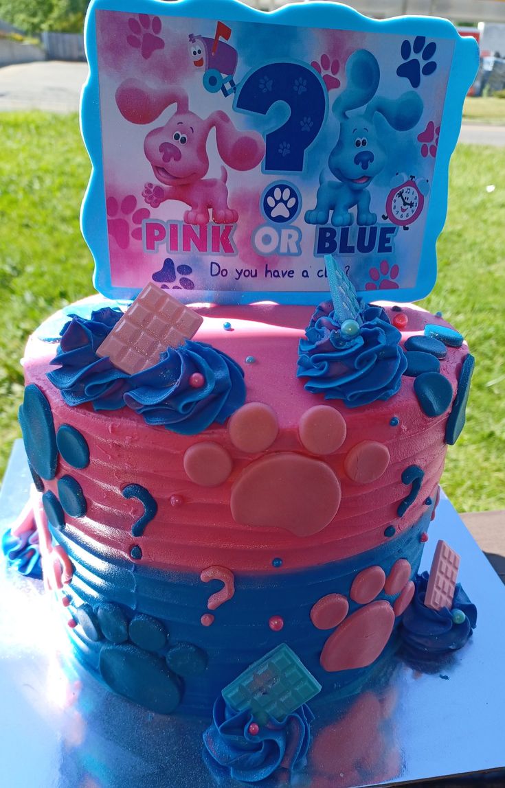 a pink and blue birthday cake sitting on top of a table