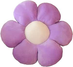 a purple flower shaped pillow sitting on top of a white surface