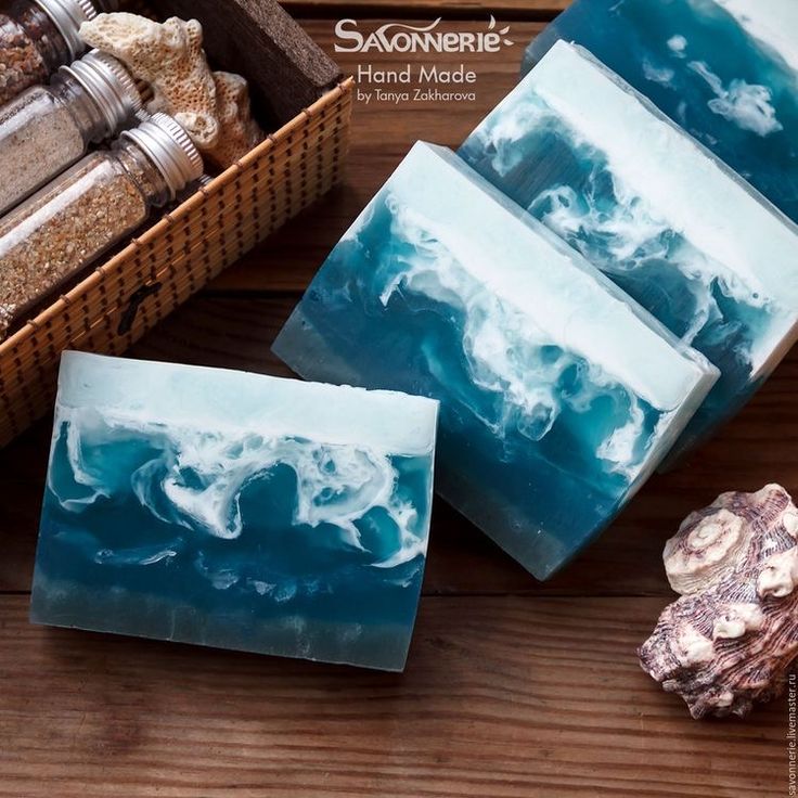 three soap bars sitting on top of a wooden table next to rocks and other items