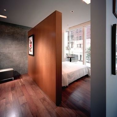 a bedroom with wood floors and white walls