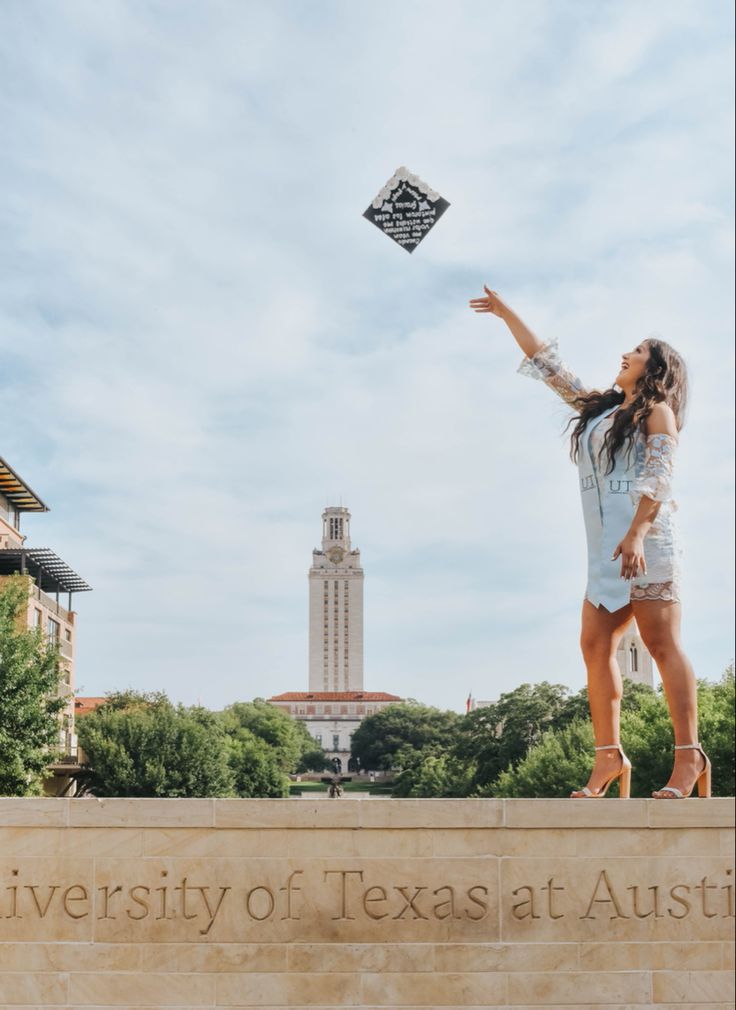 a woman flying a kite in front of the university of texas at austin