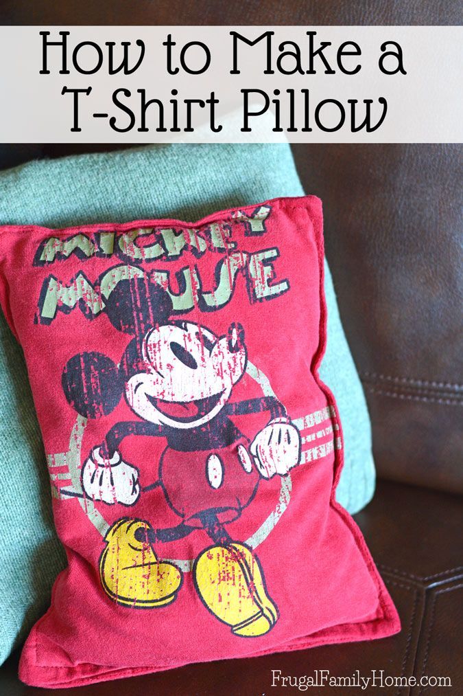 a mickey mouse pillow sitting on top of a couch next to a brown leather chair