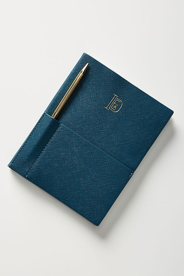 a blue notebook with a gold pen on top