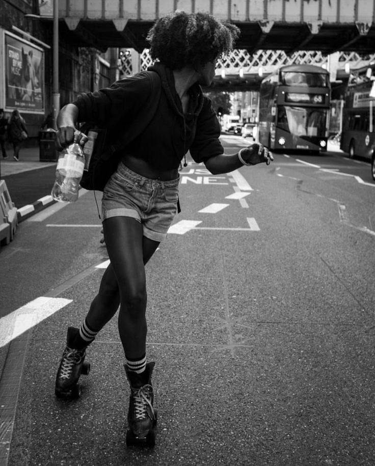 a woman riding a skateboard down the middle of a street