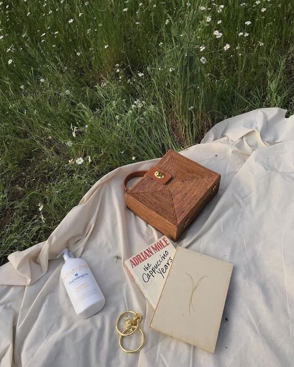 a wooden box sitting on top of a white sheet next to a bottle of lotion