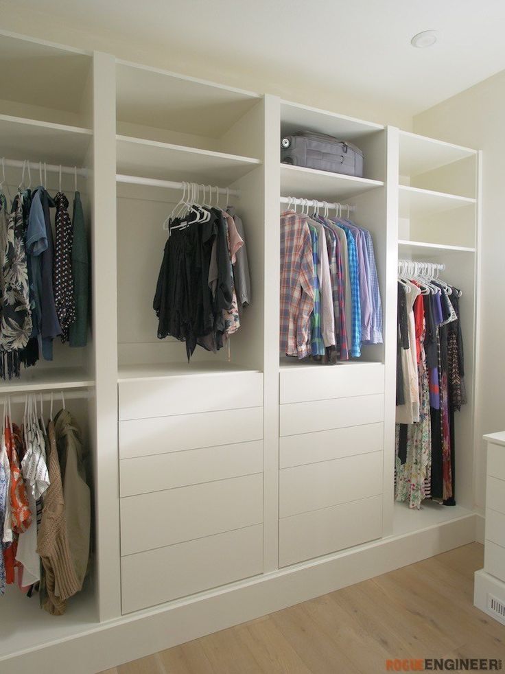 an organized closet with clothes hanging on hooks