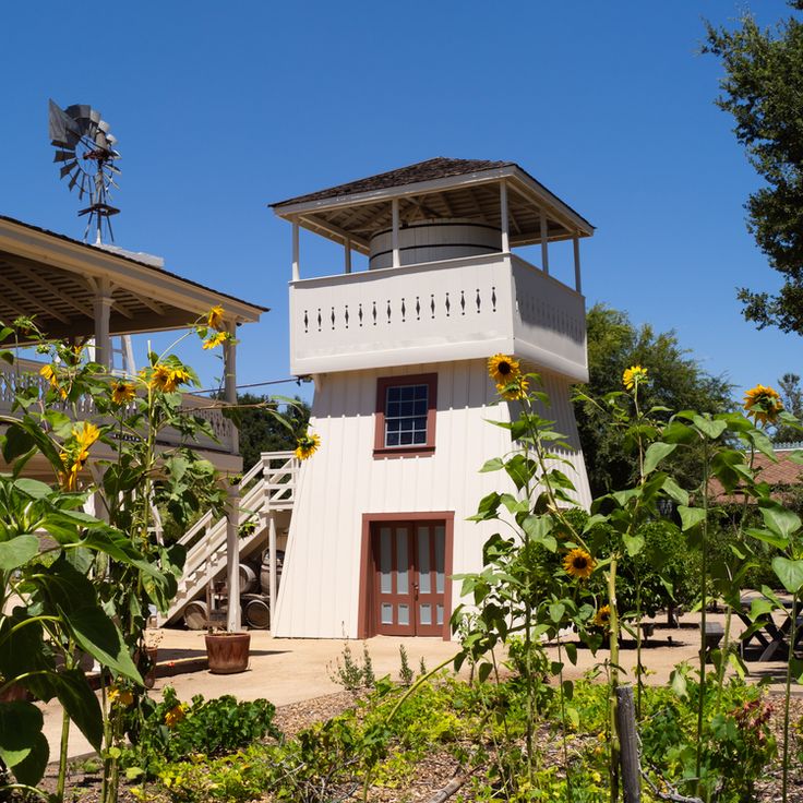 a white house with sunflowers in the foreground