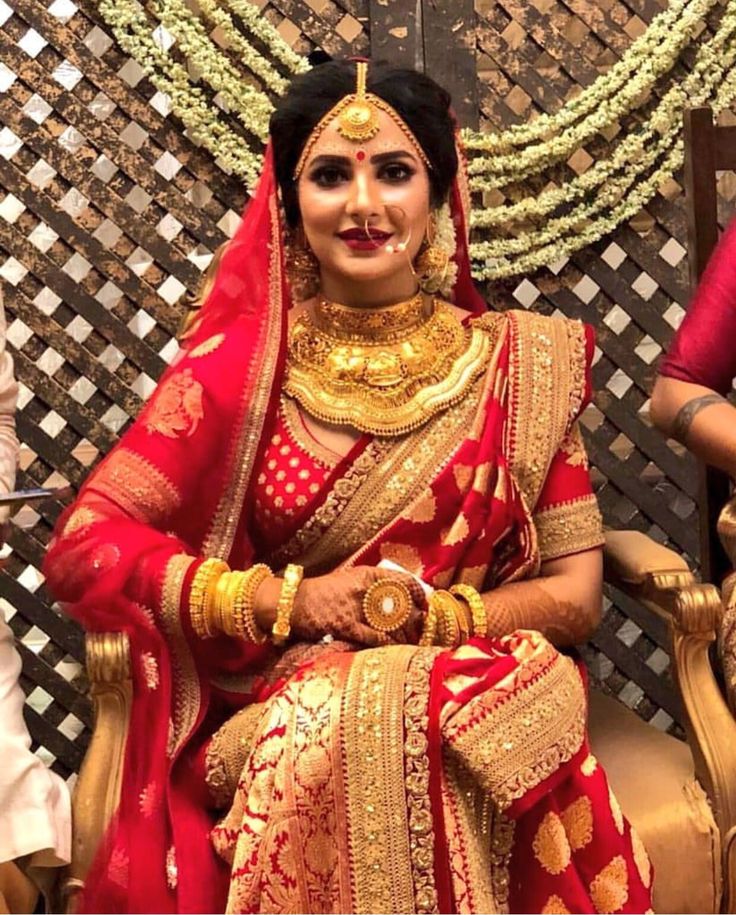 two women dressed in red and gold sitting next to each other