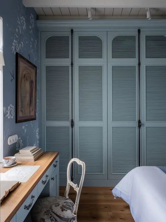 a bedroom with blue walls and wooden floors