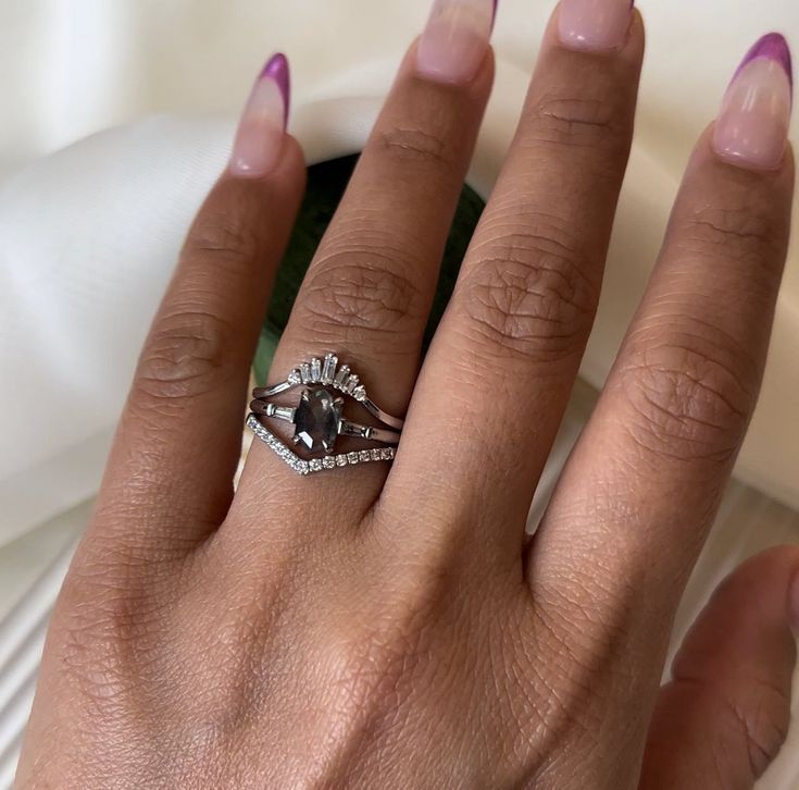 a woman's hand with a diamond ring on her left hand and purple nail polish