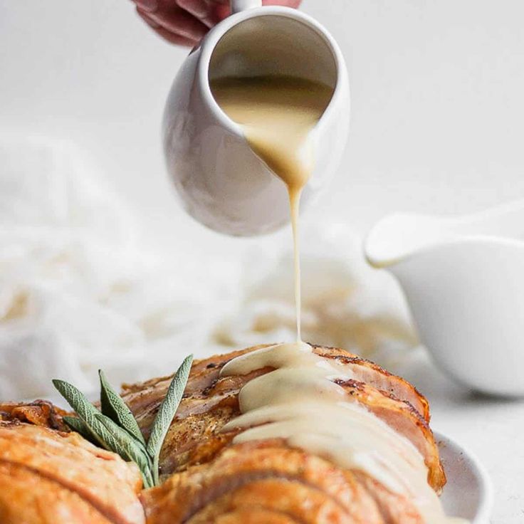 a person pouring sauce on some bread