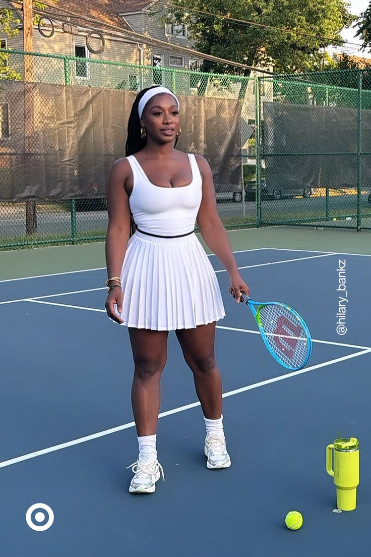 a woman standing on a tennis court holding a racquet and ball in her hand