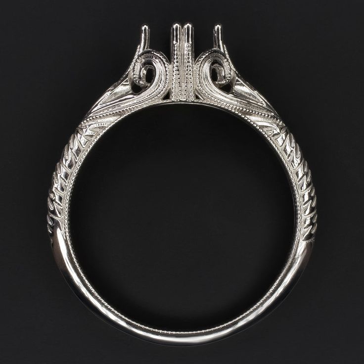 an antique style engagement ring with filigrees on the sides