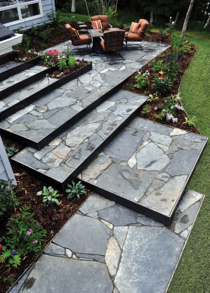 an outdoor patio with stone steps and seating area