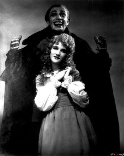 an old black and white photo of two people dressed as dracula