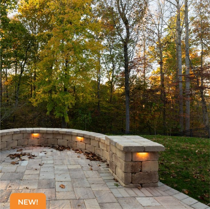 an outdoor stone bench with lights on it