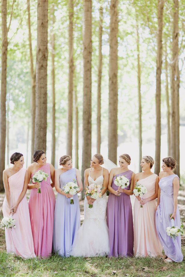 a group of women standing next to each other in front of some trees and grass