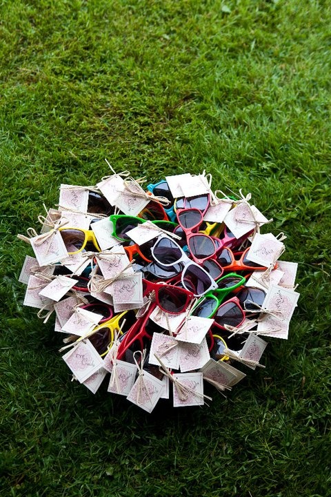 a bunch of sunglasses that are laying on the ground in the grass with some paper