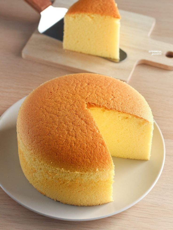 two pieces of cake on a plate with a knife and cutting board in the background