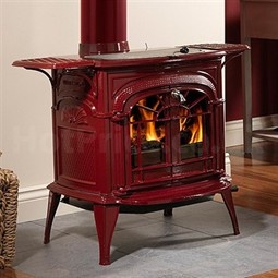 a red stove sitting on top of a hard wood floor next to a fire place