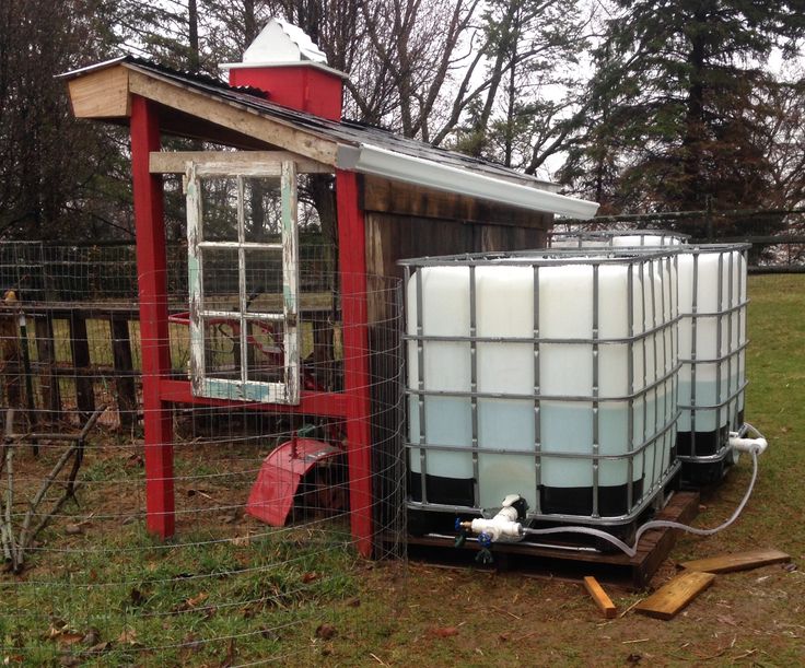 a chicken coop with a large water tank next to it