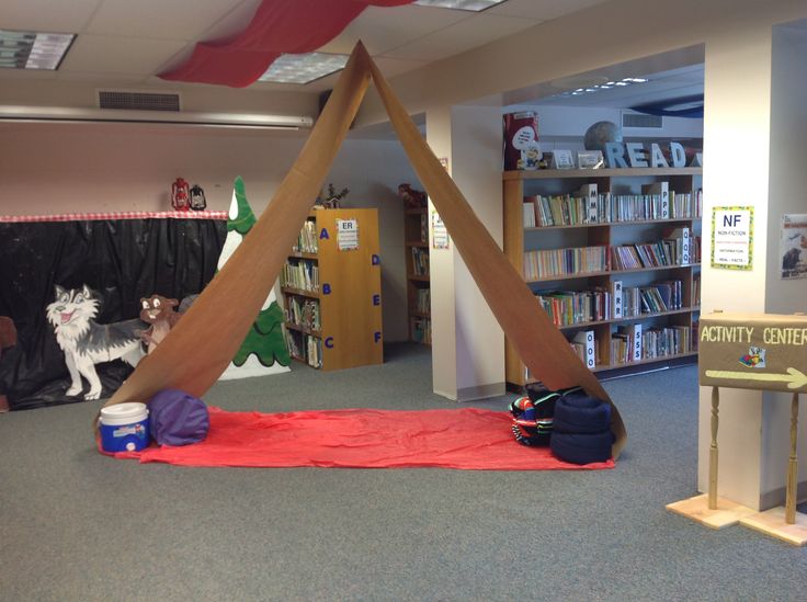 an indoor play area with bookshelves, toys and other items on the floor