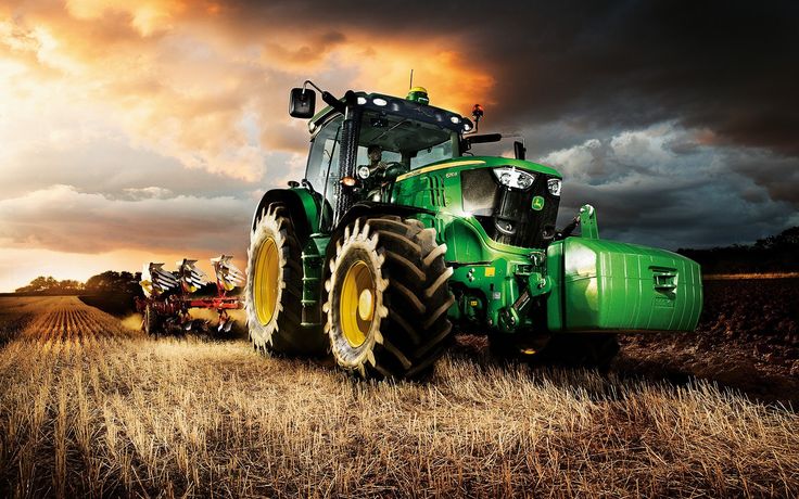 a green tractor is parked in the middle of a field