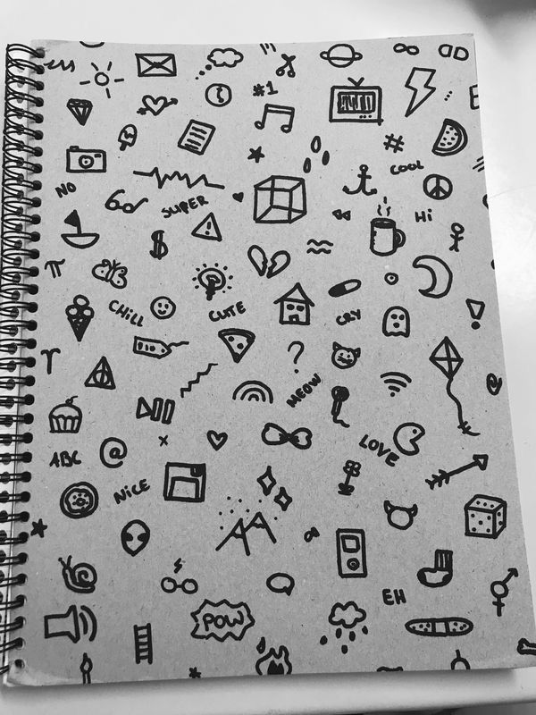 a notebook with doodles on it sitting on top of a table