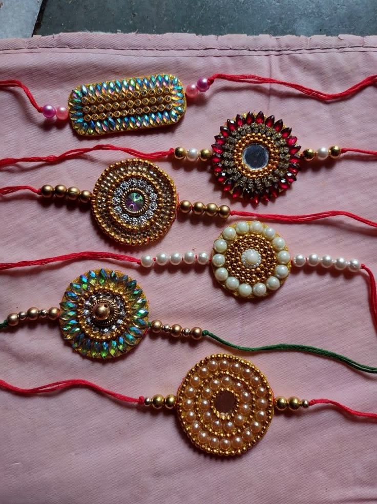 several beaded bracelets are displayed on a pink cloth