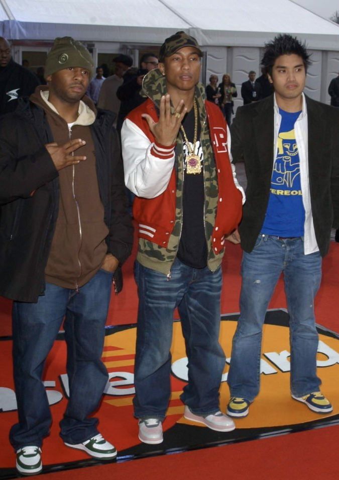 three young men standing next to each other on a red carpet