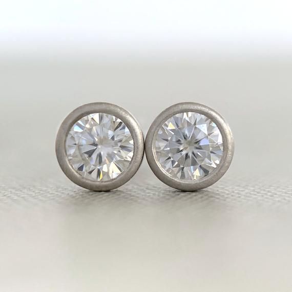 4 mm moissanite stud earrings, bezel set in 14k yellow, rose or white gold, or sterling silver. 14k white gold is pictured except for 6th photo which shows sterling silver. These earrings are made to order and will ship within 3-5 days.DETAILS- 4 mm moissanite- bezel setting - satin finish- solid 14k gold or sterling silver- white gold contains nickel, not rhodium plated- sold sterling silver or 14k gold backs- made to order within 3-5 daysWhat is Moissanite?Moissanite is lab created silicon car Silver Earrings With Single Diamond For Anniversary, Everyday Fine Jewelry Earrings With Bezel Setting, Classic Everyday Jewelry With Tension Setting, Anniversary Diamond Earrings With Tension Setting, Silver Diamond Earrings With Round Cut, Modern White Gold Earrings With Bezel Setting, Minimalist Bezel Set Earrings For Formal Occasions, Gift Round Diamond Earrings With Tension Setting, Minimalist Diamond Earrings With Bezel Setting For Formal Occasions