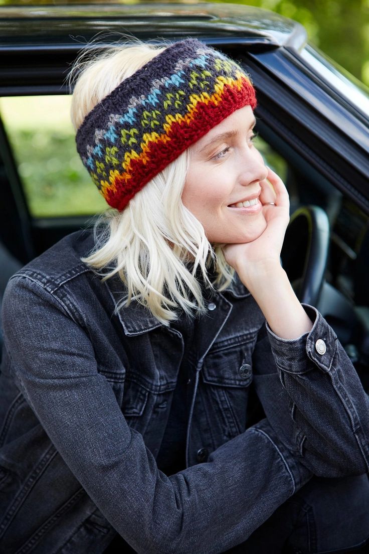 a woman with blonde hair wearing a colorful knitted headband sitting in a car