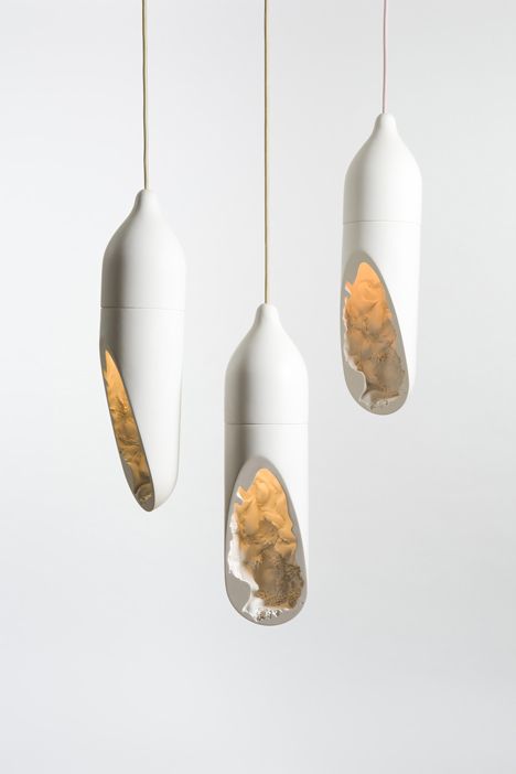 three hanging lights with different shapes and colors on them, one is white and the other is gold