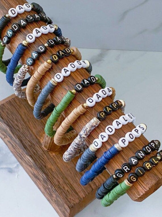 an assortment of bracelets are displayed on a wooden stand