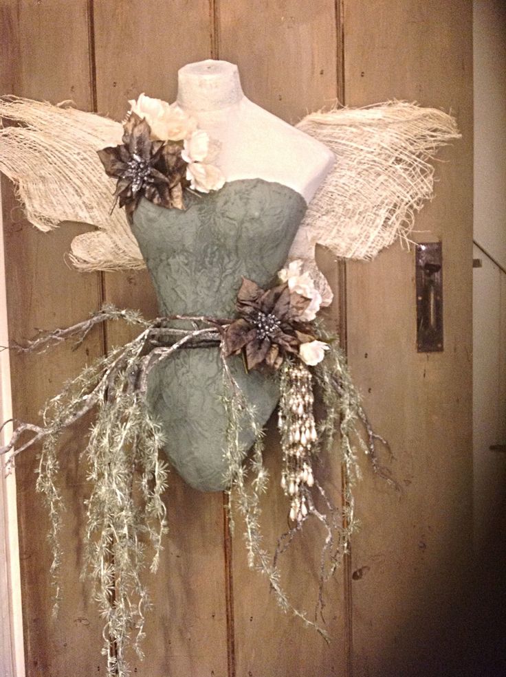 a mannequin is adorned with flowers and leaves