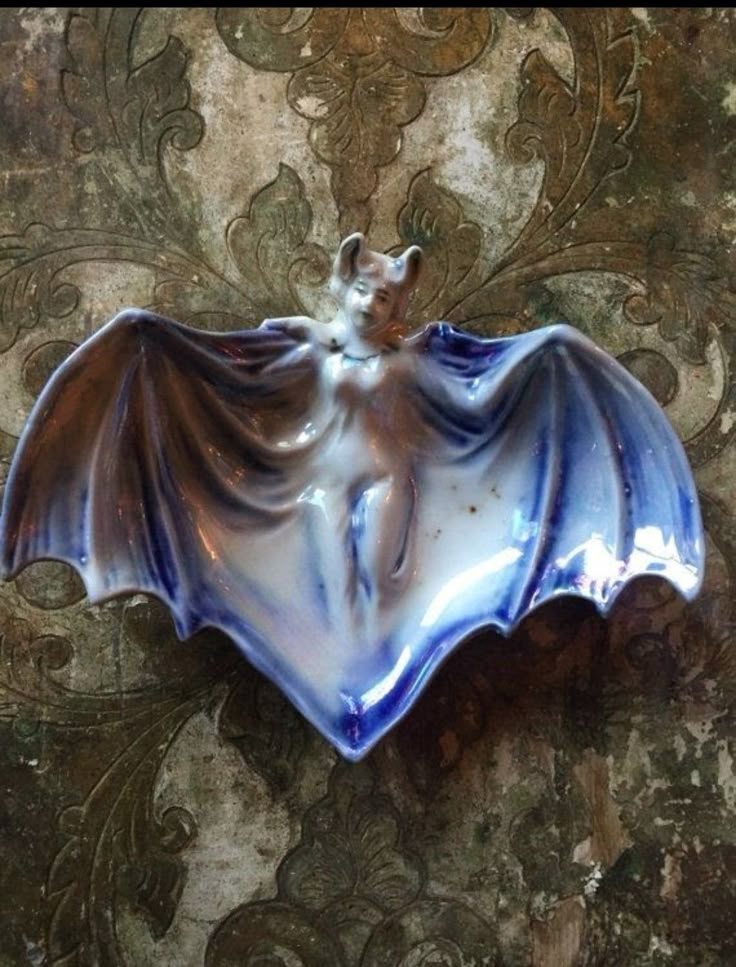 a ceramic bat hanging on the side of a wall