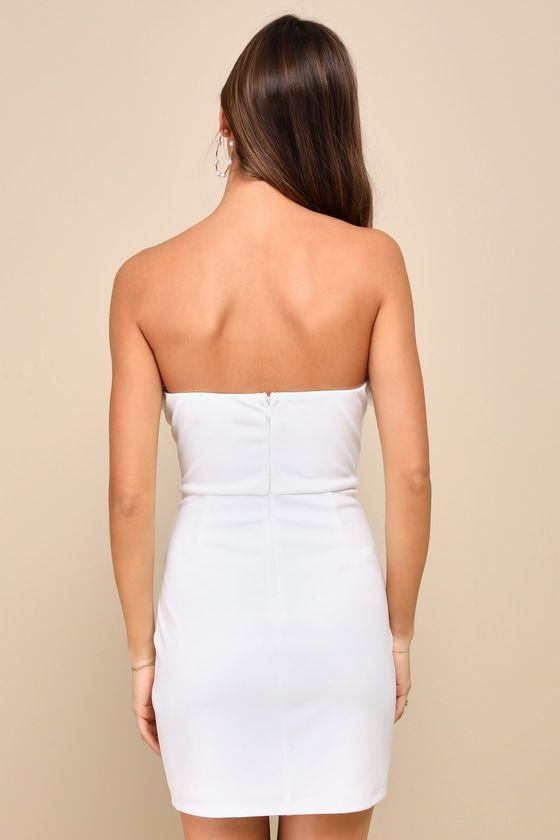 The Lulus Gorgeous Wonder White 3D Floral Applique Strapless Mini Dress is the perfect way to keep the compliments coming all night long! Stretchy crepe knit shapes this sensational dress that features a strapless seamed bodice (with hidden no-slip strips) and a straight neckline with a plunging notched detail and supportive V-bar, accented with trendy, three-dimensional floral appliques. The high, fitted waist tops a figure-flattering, bodycon skirt that finishes at a flirty mini hem. Hidden ba White Strapless Stretch Bandage Dress, Strapless Bodycon Bandage Dress For Date Night, Chic Bandeau Bodycon Dress, Cocktail Bodycon Bandeau Dress, White One-shoulder Fitted Tube Top, One Shoulder Fitted Tube Top For Date Night, One-shoulder Fitted Tube Top For Date Night, White Fitted One-shoulder Tube Top, Elegant Bodycon Bandeau Mini Dress