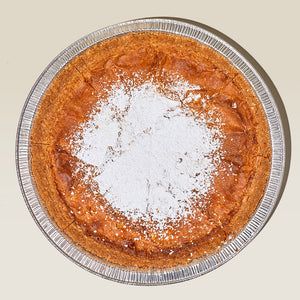 an overhead view of a pie with powdered sugar on top in a glass dish