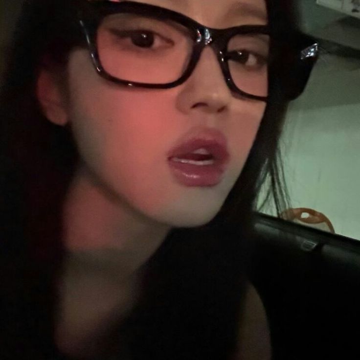 a close up of a person wearing glasses and looking at something in the distance with her mouth open