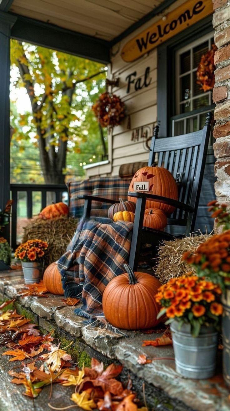 a porch decorated for fall with pumpkins and hay