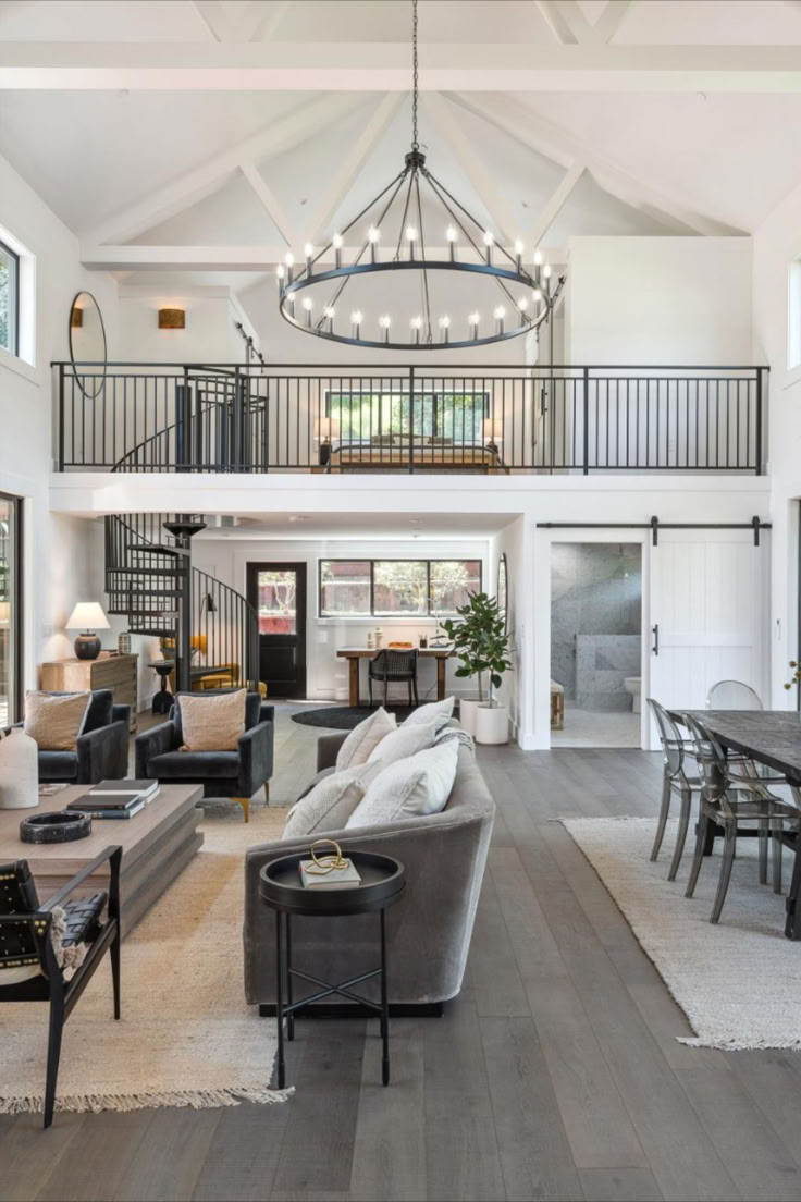 a living room filled with lots of furniture and a chandelier hanging from the ceiling