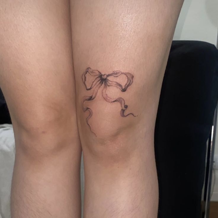 a woman's legs with tattoos on them