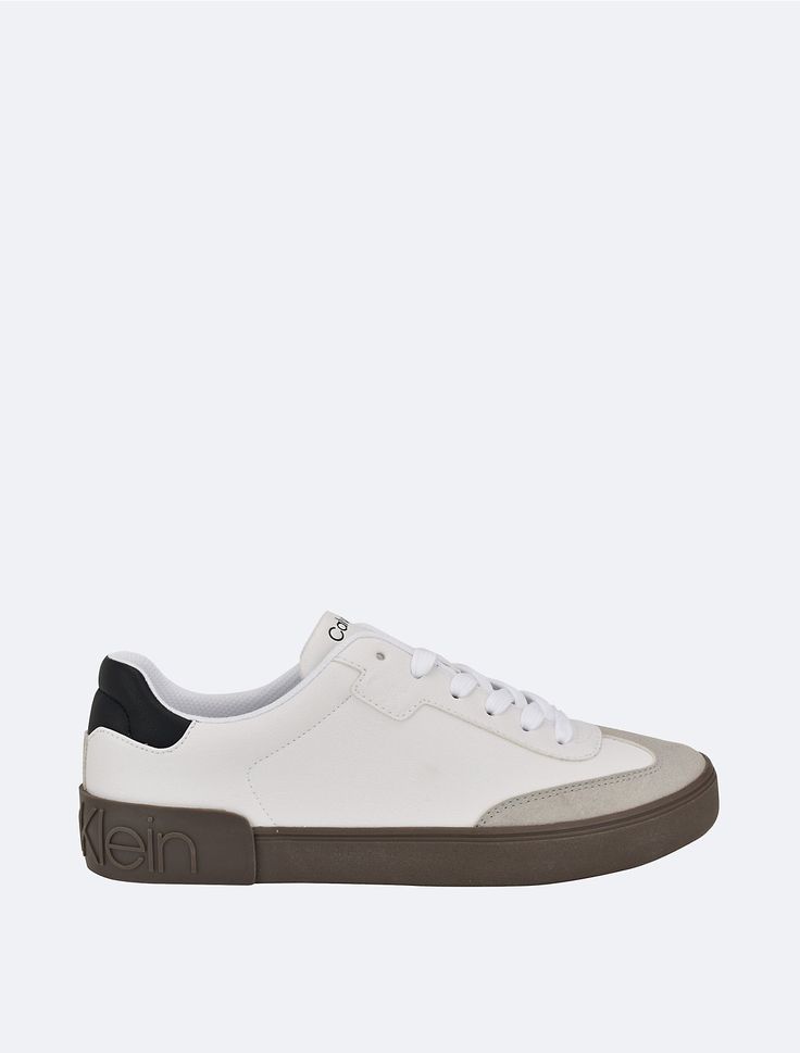 Athletic inspired, this everyday sneaker is made with faux leather and faux suede accents. Made with a low top silhouette, a padded logo footbed and a prominent Calvin Klein logo at the back sole.  Material: Faux Leather. Low Top, Faux Suede, Top Sneakers, Calvin Klein, Faux Leather, Sneakers, ? Logo, Leather