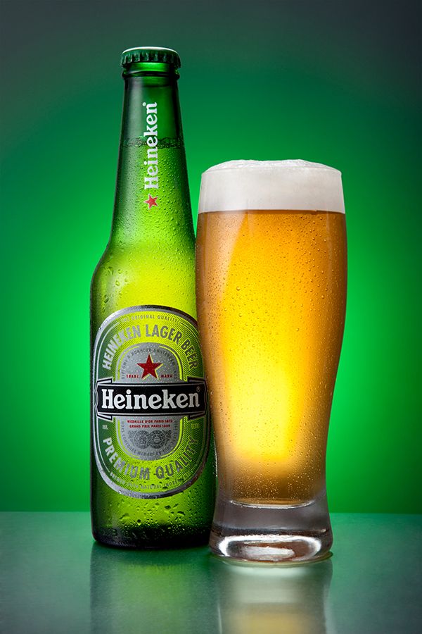 a glass and bottle of heineken beer sitting next to each other on a table