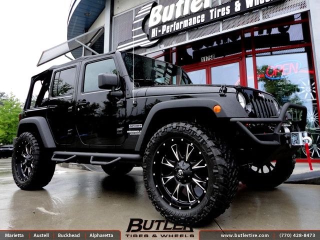 a black jeep is parked in front of a building that says butternut tires and wheels