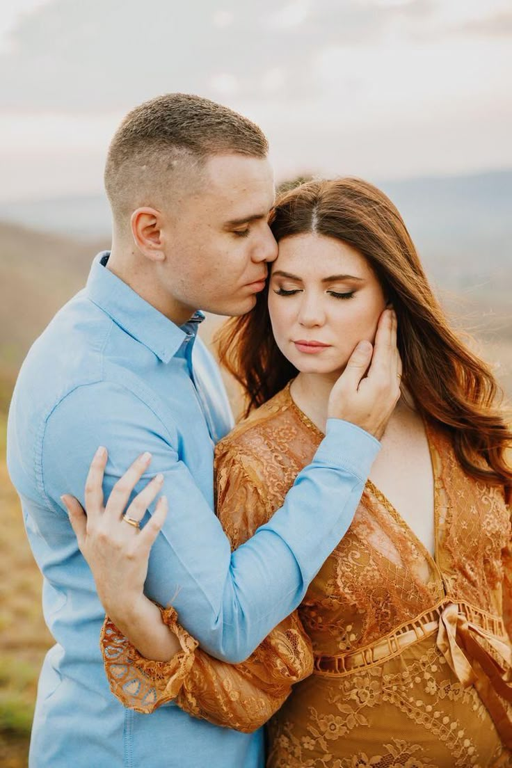 a man and woman embracing each other in an open field