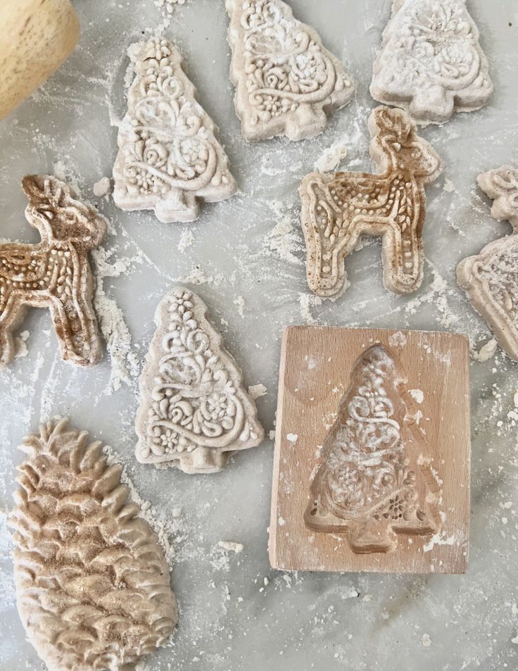 some cookies are sitting on a table next to pine cones and a cookie molder