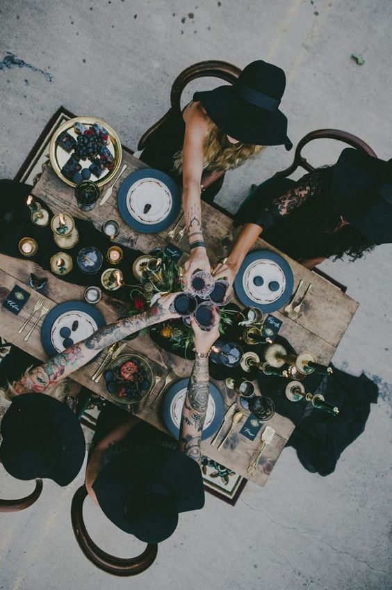 a group of people sitting around a table covered in food