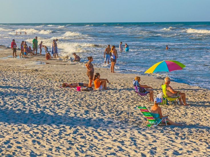 many people are on the beach and in the water